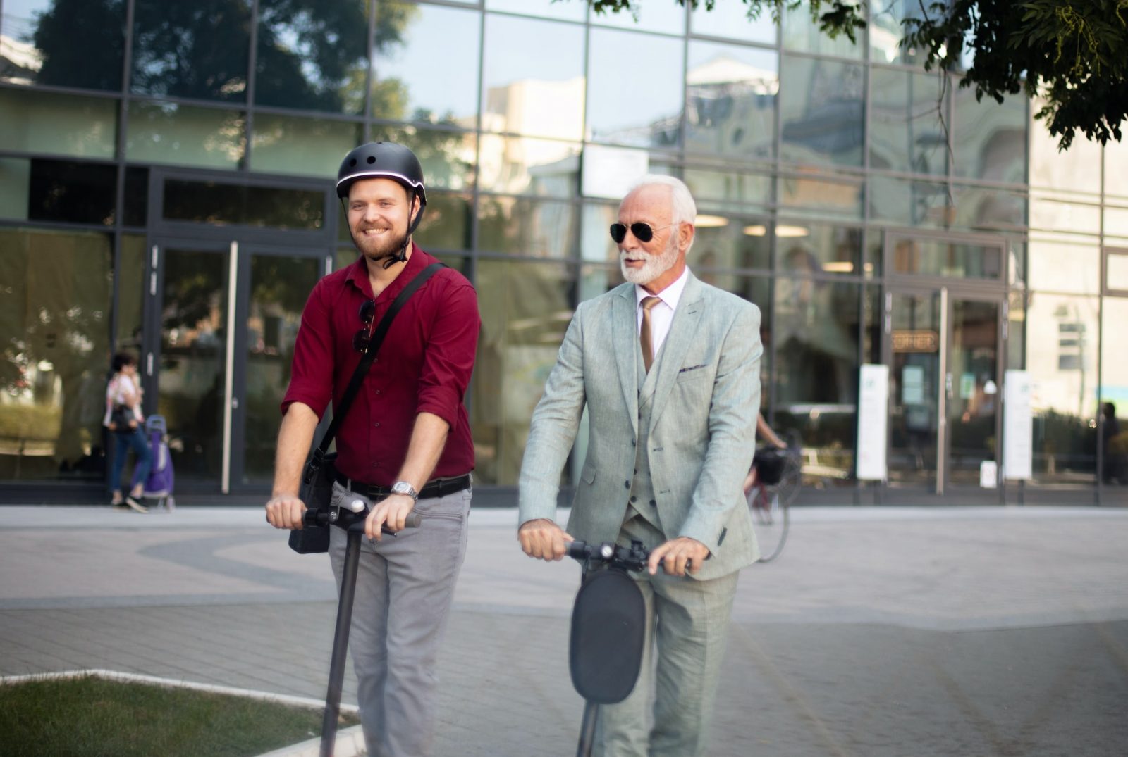 two business men riding electric scooter in the city