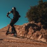 a man rides uphill on an off-road electric scooter