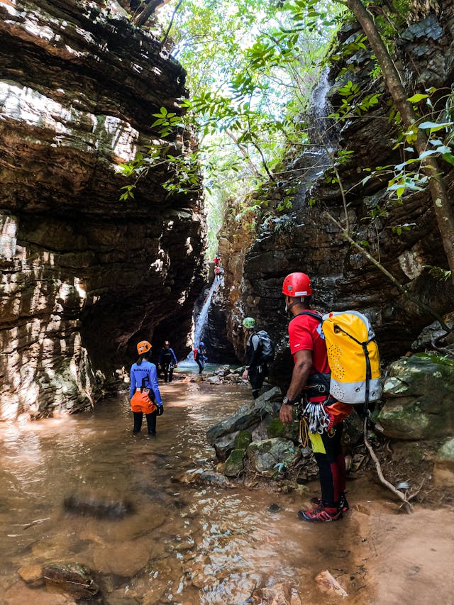 people-walking-across-stream-in-mountains